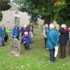 Liz Beevers shows the group an interesting headstone in Currie kirkyard